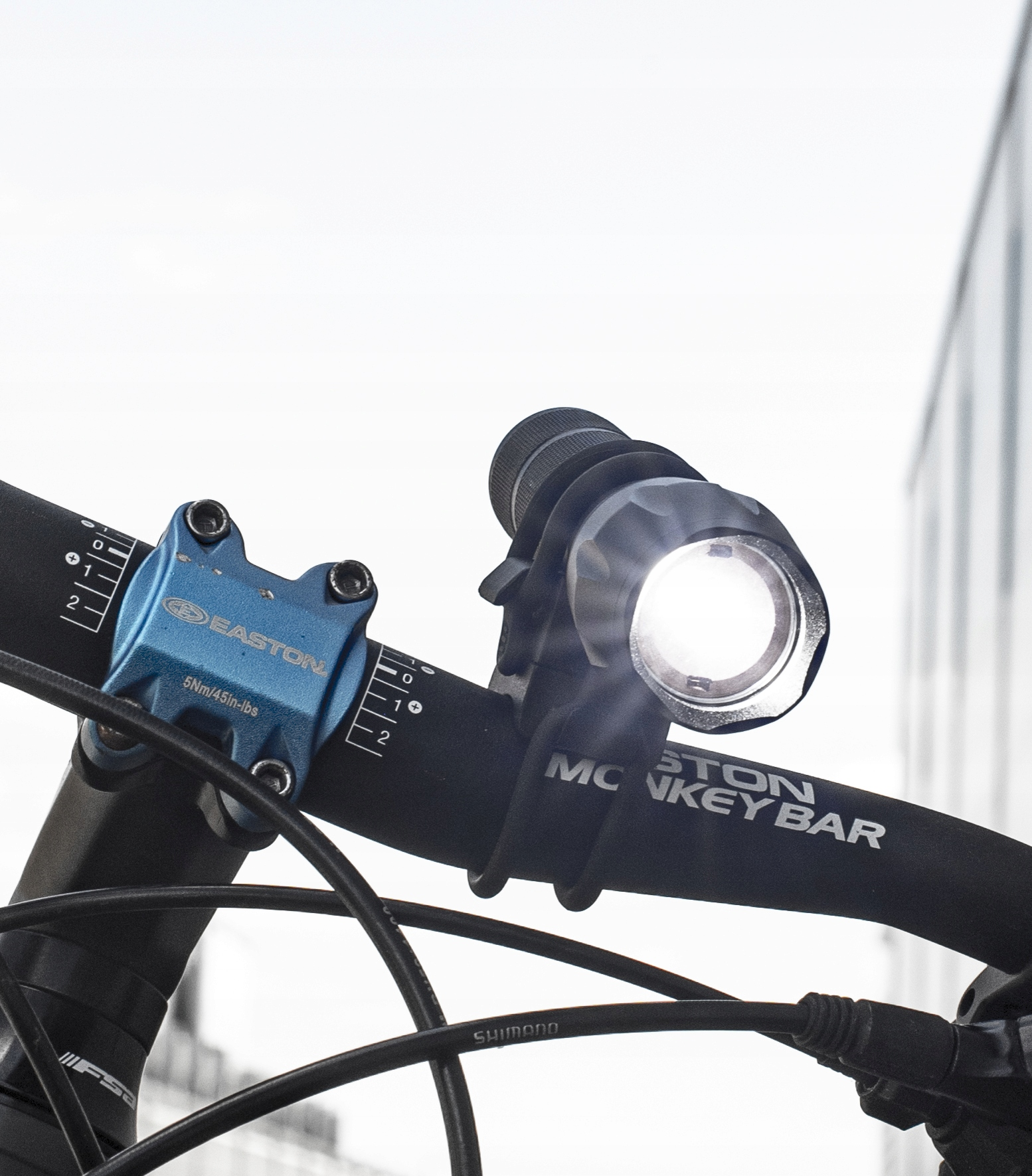 Un manubrio per bicicletta con attacco Easton blu e luce anteriore brillante.