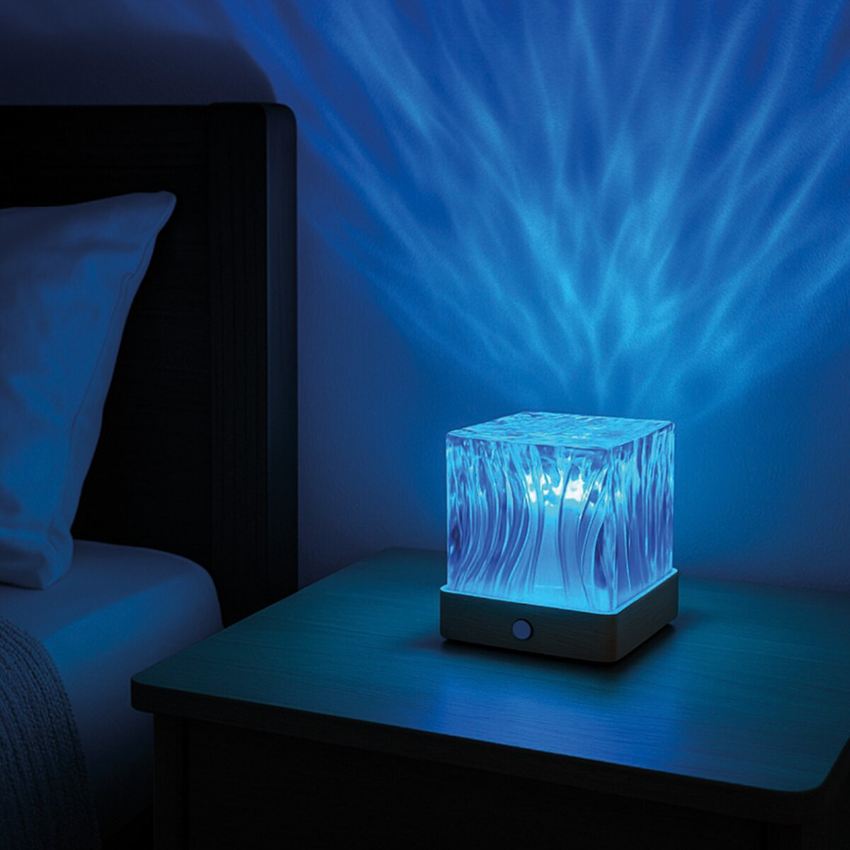 Ein würfelförmiger Lampen projiziert blaues Licht mit Wellenmuster an die Wand.
