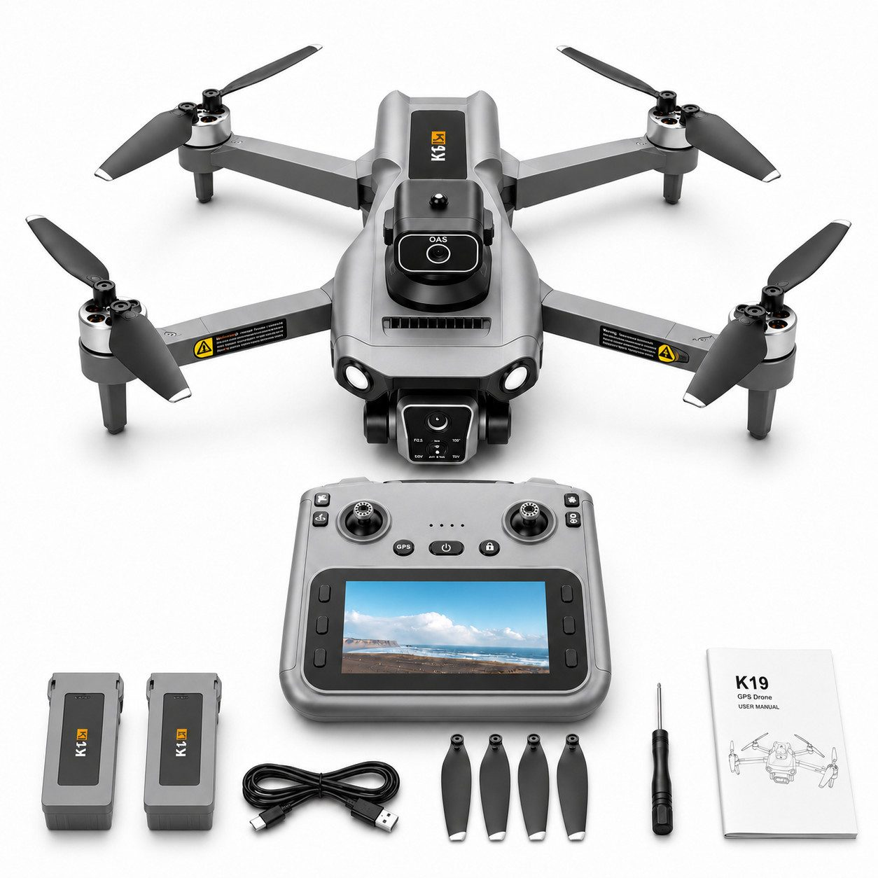 Graue Drohne mit Controller, Batterien, Propellern, USB-Kabel, Schraubendreher und Handbuch.