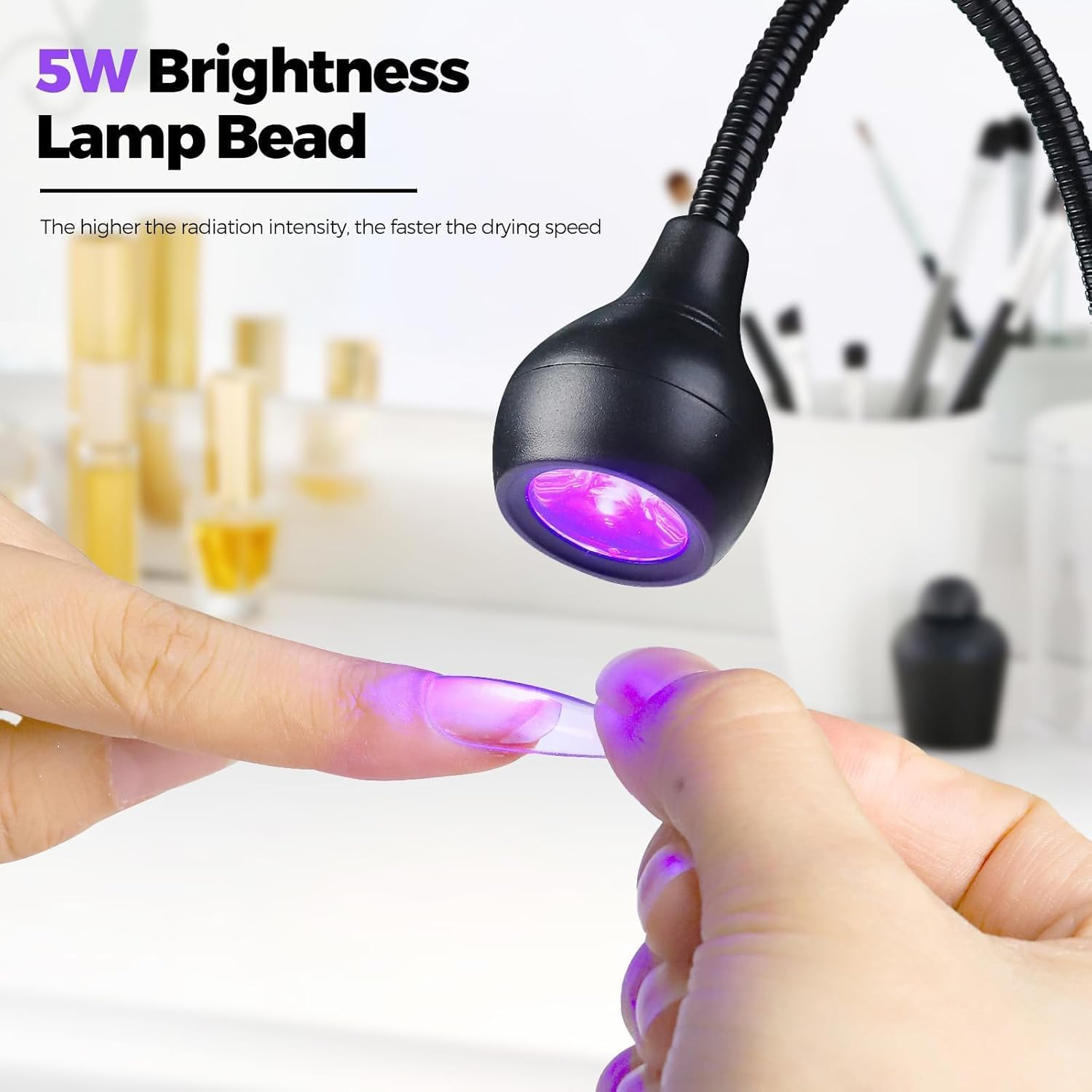 Eine Hand hält einen künstlichen Nagel unter eine UV-Lampe.
