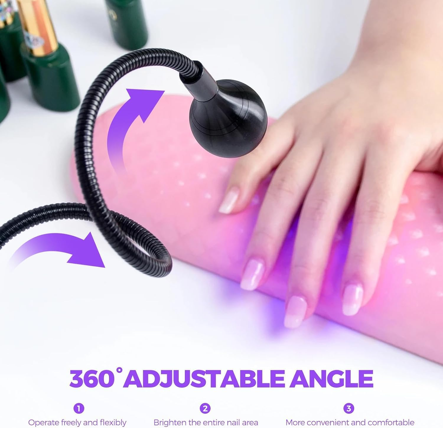 Eine schwarze flexible Lampe beleuchtet eine Hand mit hellrosa Nägeln auf einem rosa Pad. Grüne Flaschen im Hintergrund.