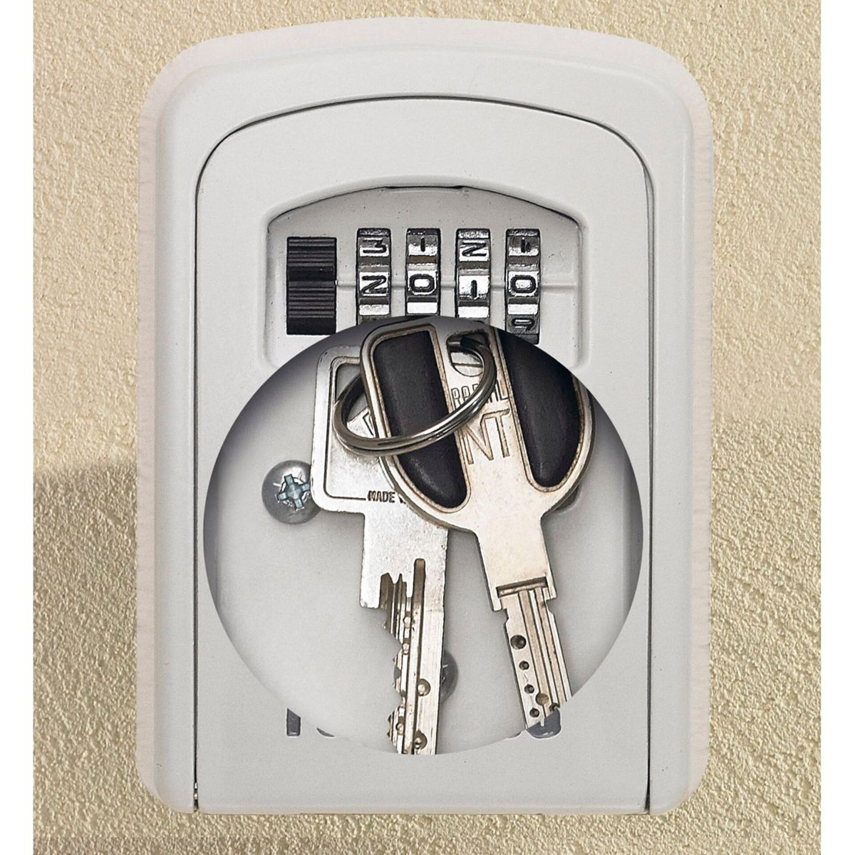 Un portachiavi bianco con combinazione e chiavi all'interno, montato su un muro testurizzato.