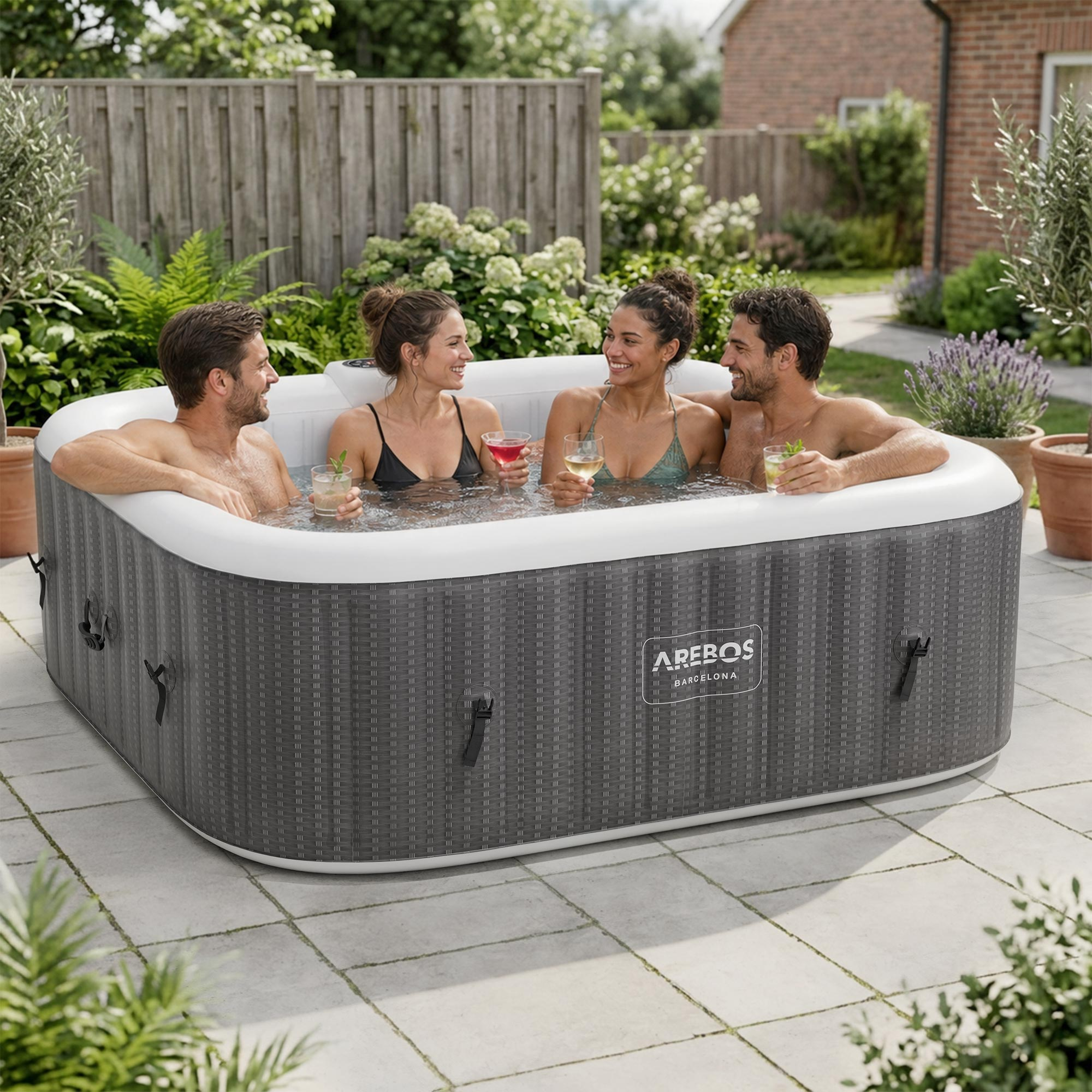 Vier lachende Personen in einem aufblasbaren Whirlpool im Garten, mit Getränken.