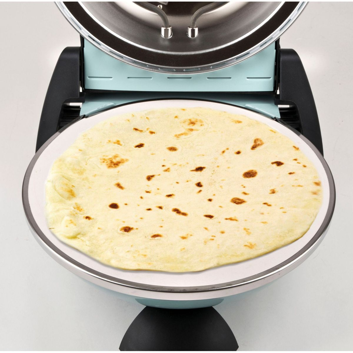 Ein hellblauer Tortilla-Maker mit einer gekochten Tortilla darin.