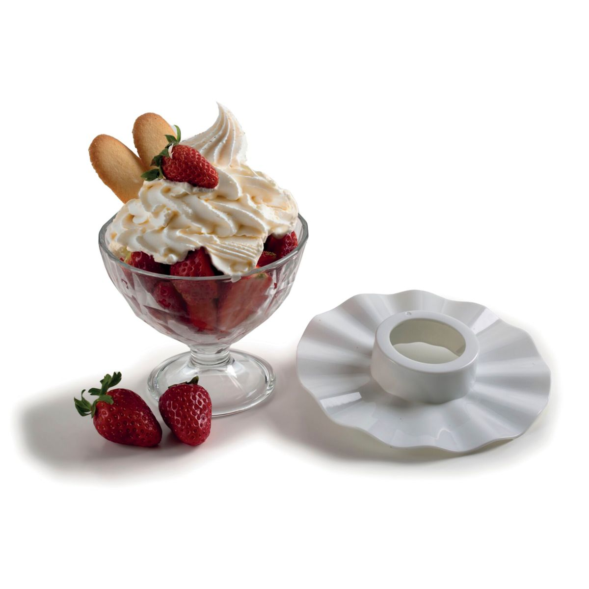 Un dessert in bicchiere con fragole e panna montata, accanto un piatto bianco.