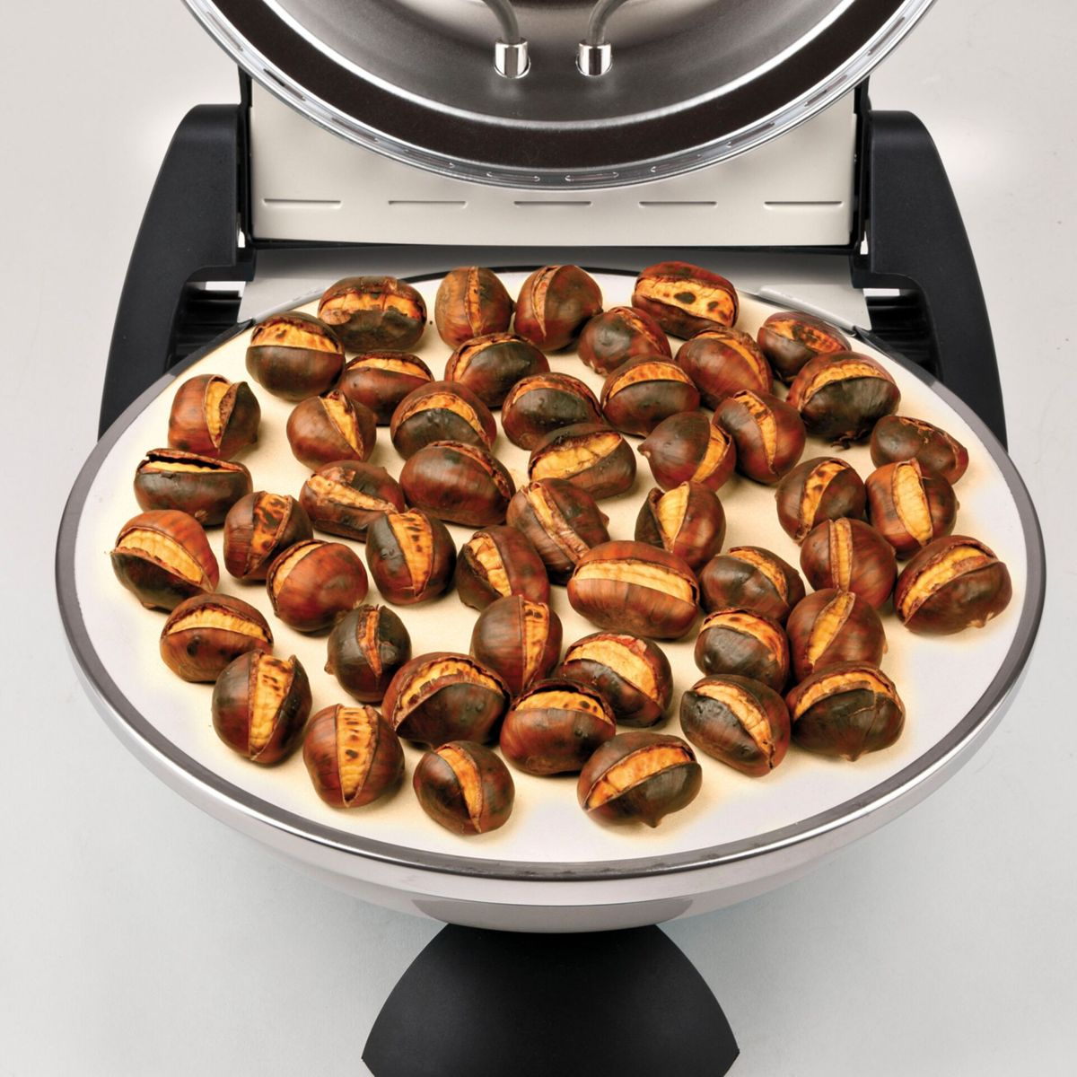 Castagne arrosto intere con guscio spaccato giacciono su un piatto bianco.