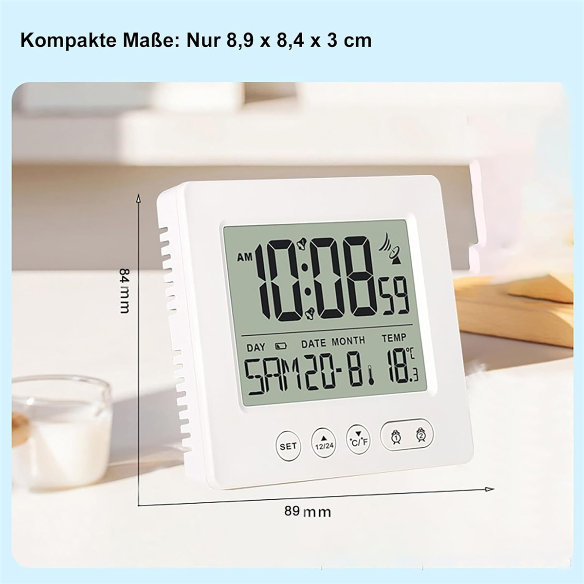 Ein weißer Digitalwecker zeigt Zeit, Datum und Temperatur an. Maße: 8,9 x 8,4 cm.