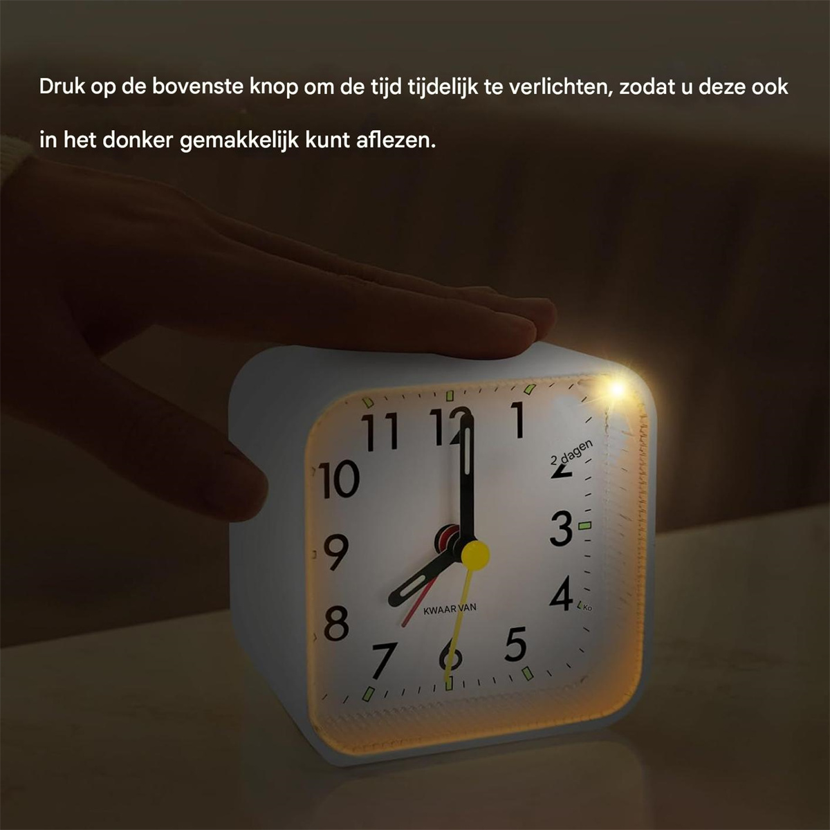 Eine Hand drückt auf die Oberseite eines weißen Weckers, um das Zifferblatt zu beleuchten.