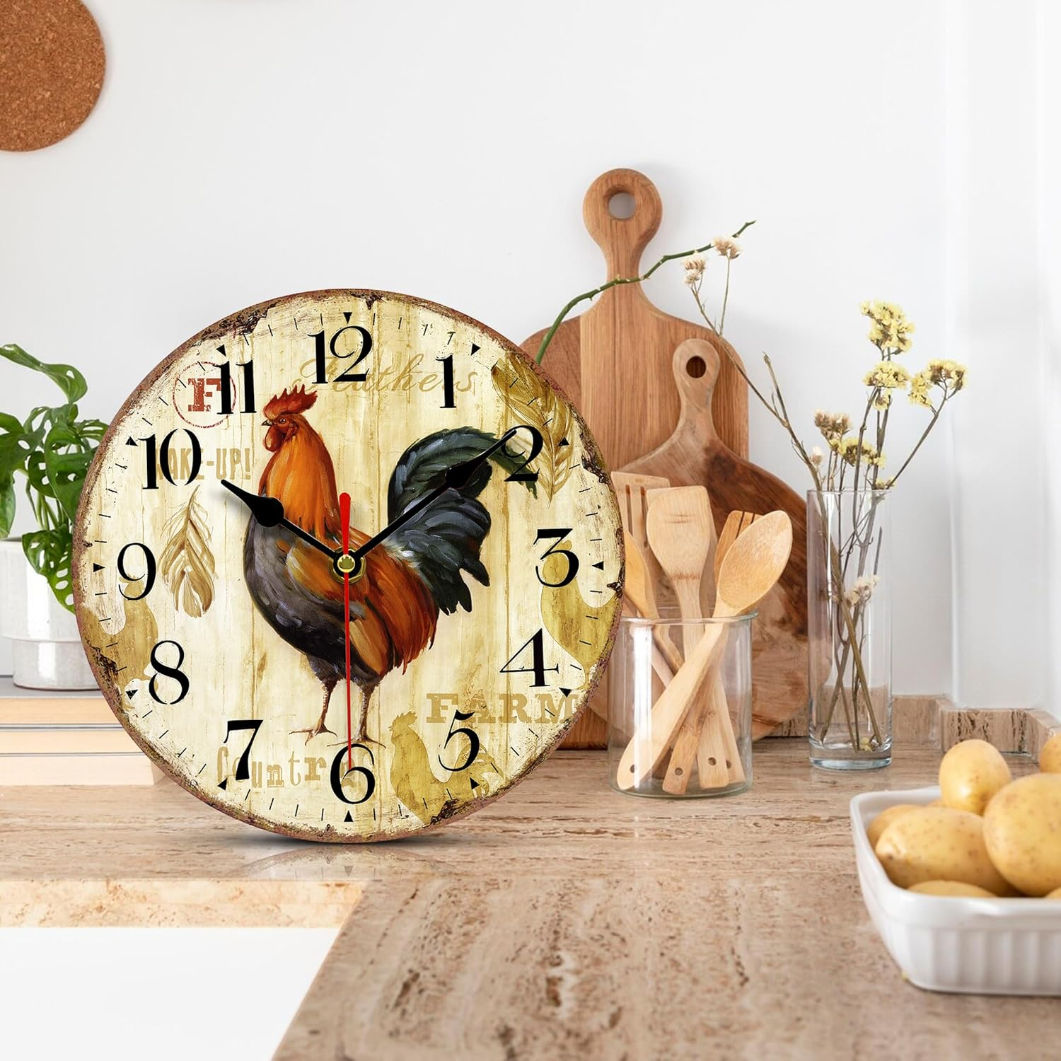 Eine Wanduhr mit einem Hahn-Design auf einem Holzhintergrund steht auf einer Arbeitsplatte.
