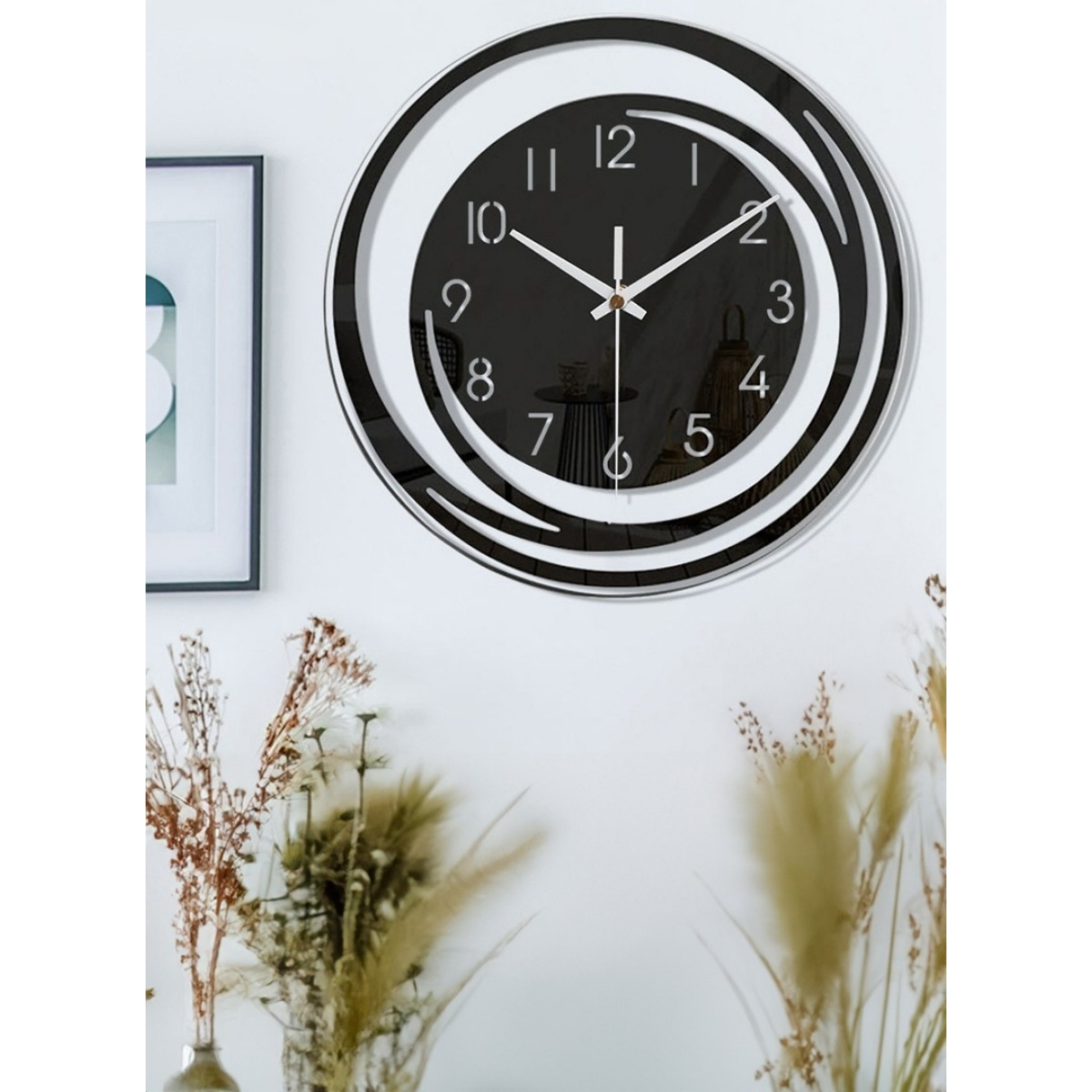 Moderne schwarze Wanduhr mit weißen Ziffern und Zeigern auf weißer Wand.