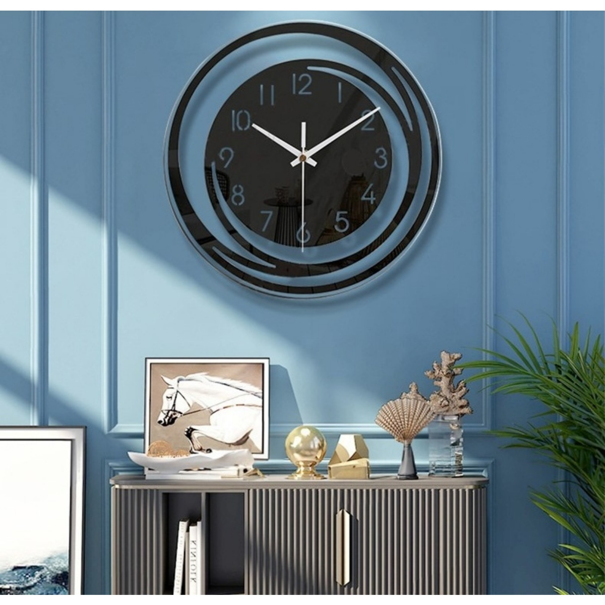 Eine schwarze Wanduhr mit weißen Zeigern hängt an einer blauen Wand über einem Schrank.