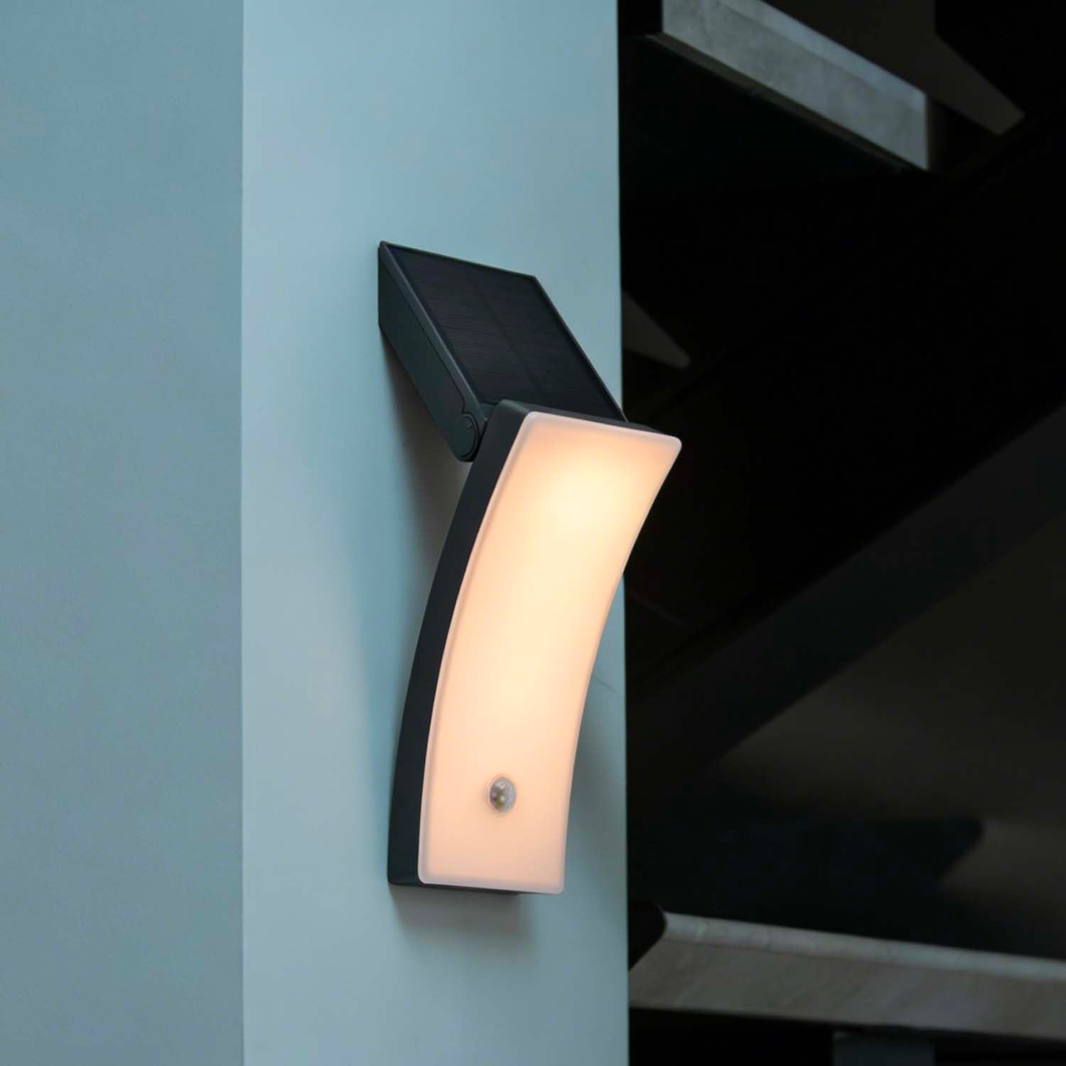 Eine moderne Wandleuchte mit Solarpanel und Bewegungssensor leuchtet hell.