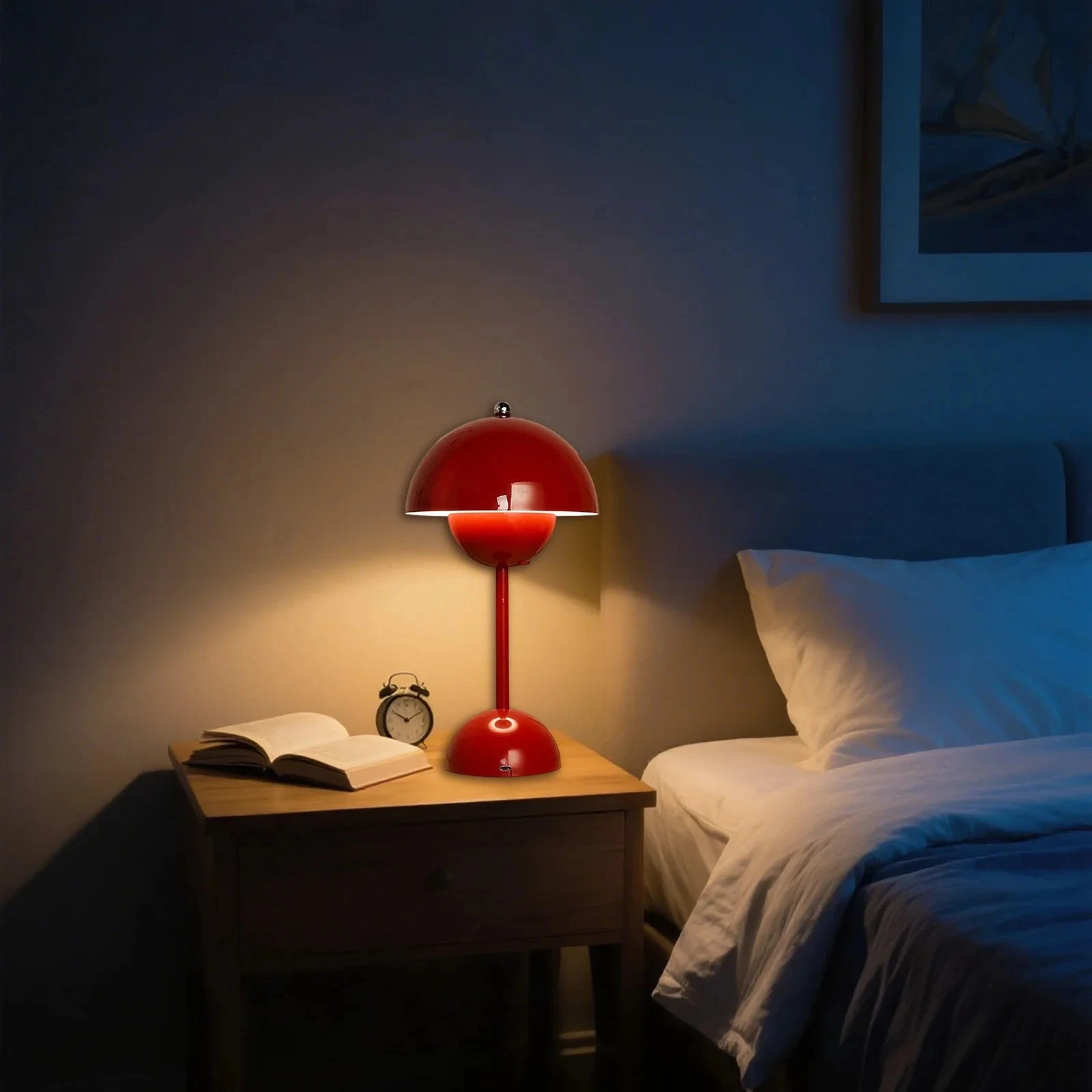 Ein rotes Nachttischlampen-Set mit Buch und Wecker auf einem Holztisch.