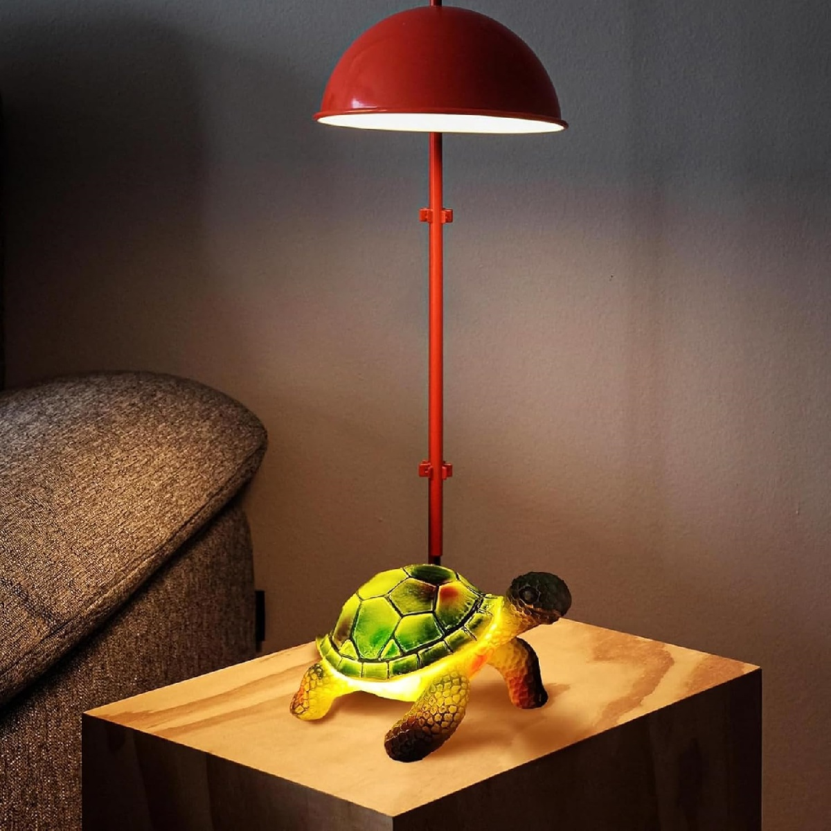 Eine leuchtende Schildkrötenlampe steht auf einem Holztisch neben einem Sofa.