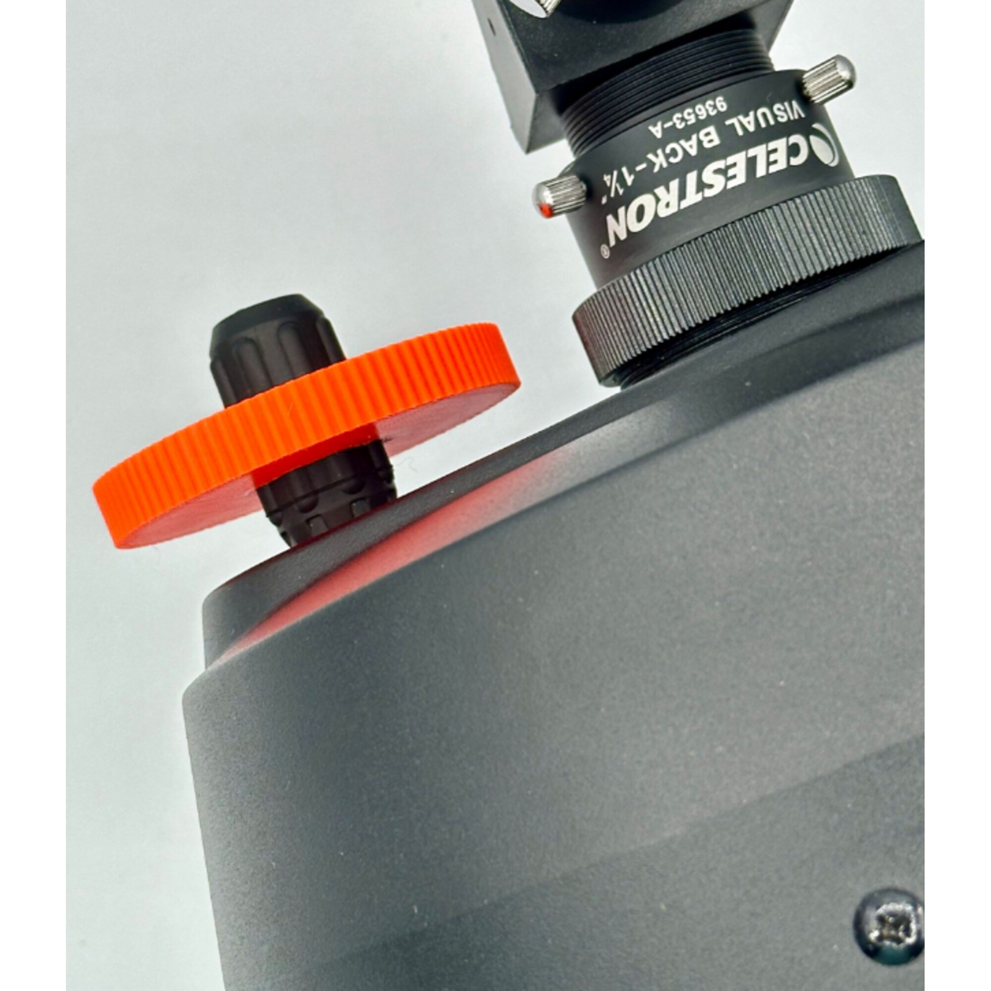 Nahaufnahme eines Teleskopadapters mit orangefarbenem Einstellrad und Celestron-Logo.
