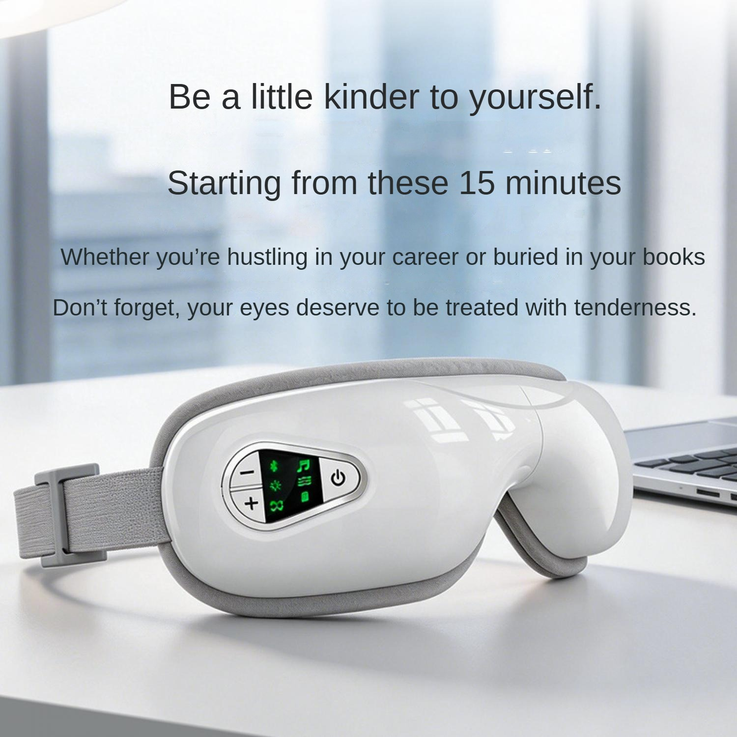 Weißer Augenmassager mit Digitalanzeige und Knöpfen auf einem Schreibtisch neben einem Laptop.
