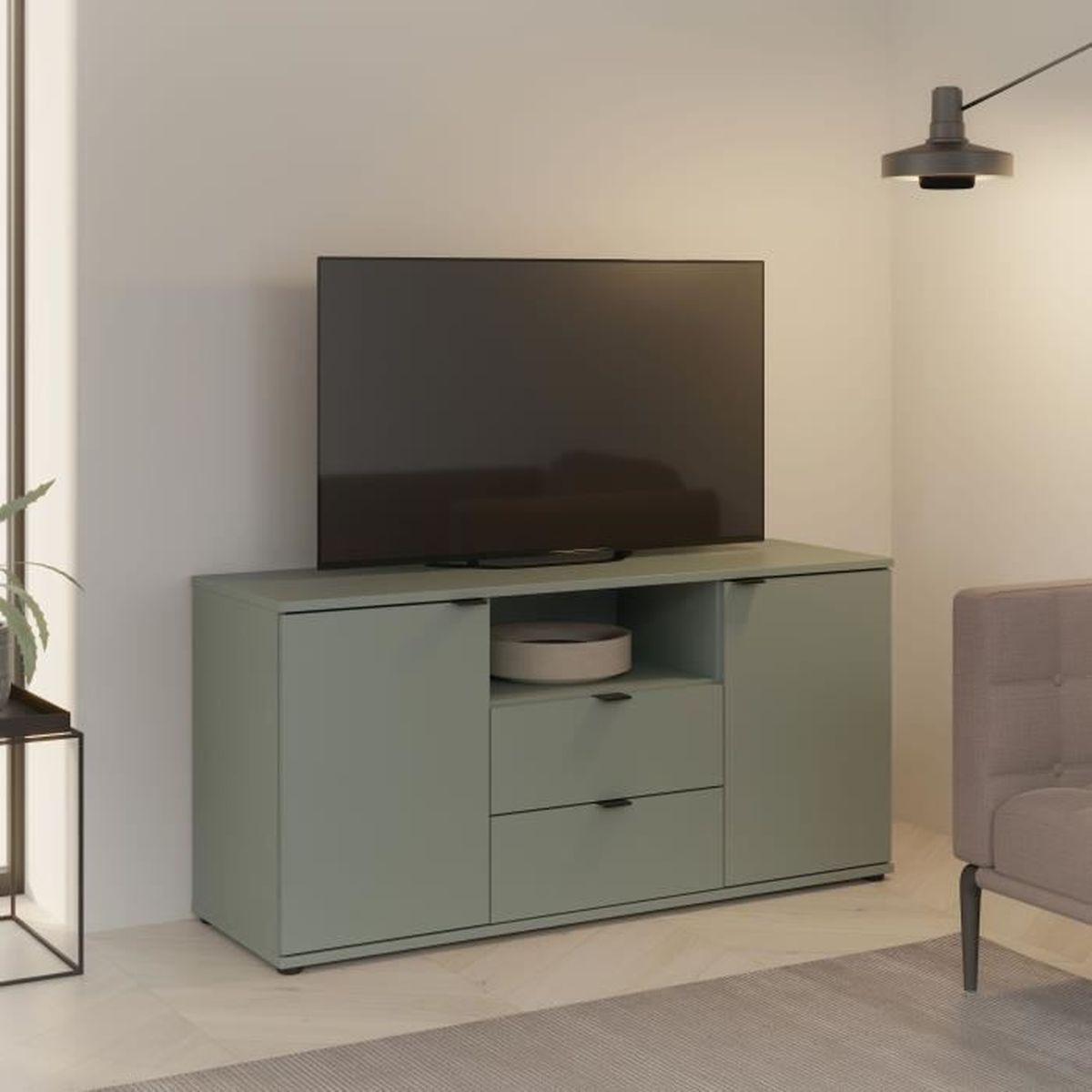 Ein flaches Fernsehgerät steht auf einem hellgrünen Schrank mit Schubladen und Türen.