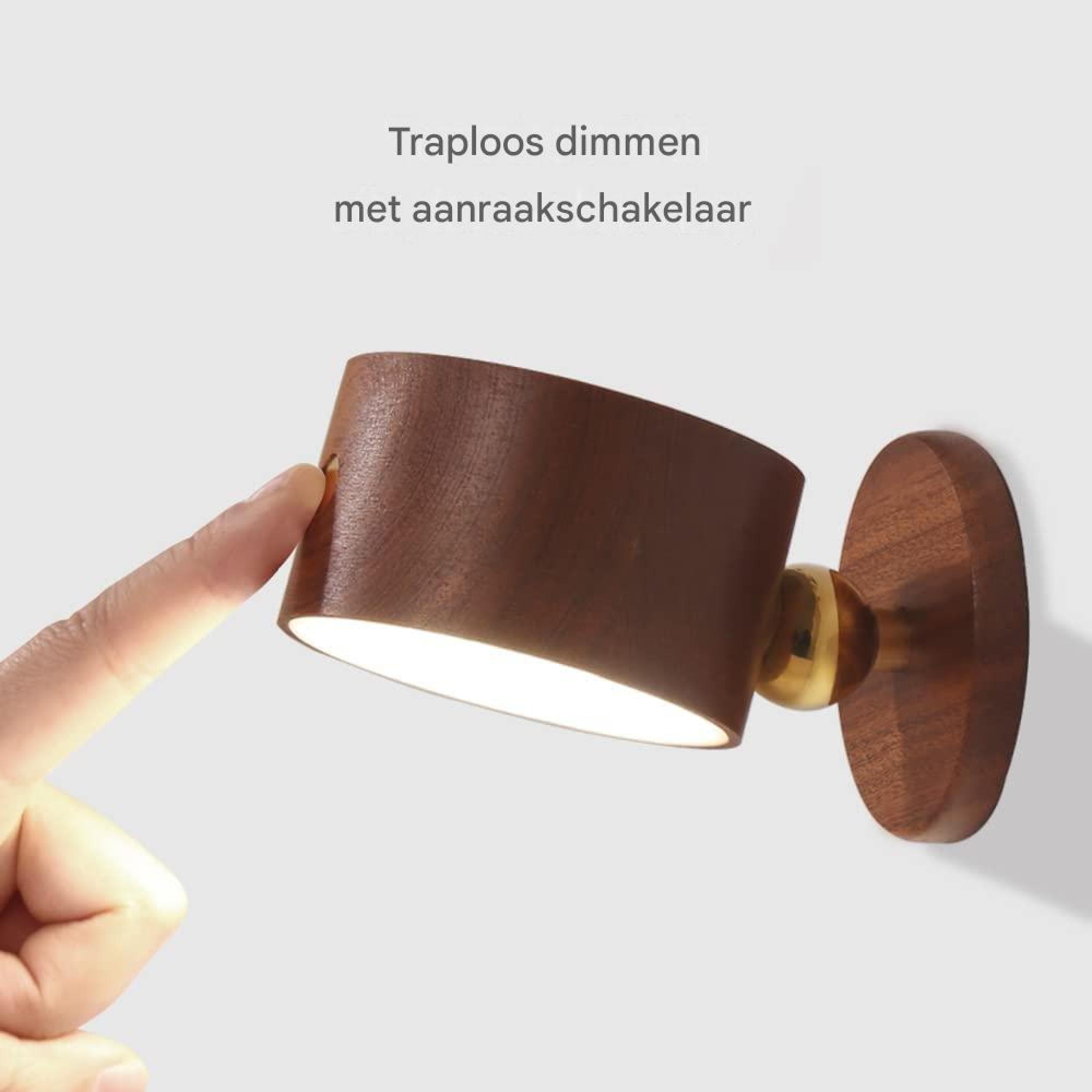 Ein Finger berührt eine hölzerne Lampe mit Messinggelenk.