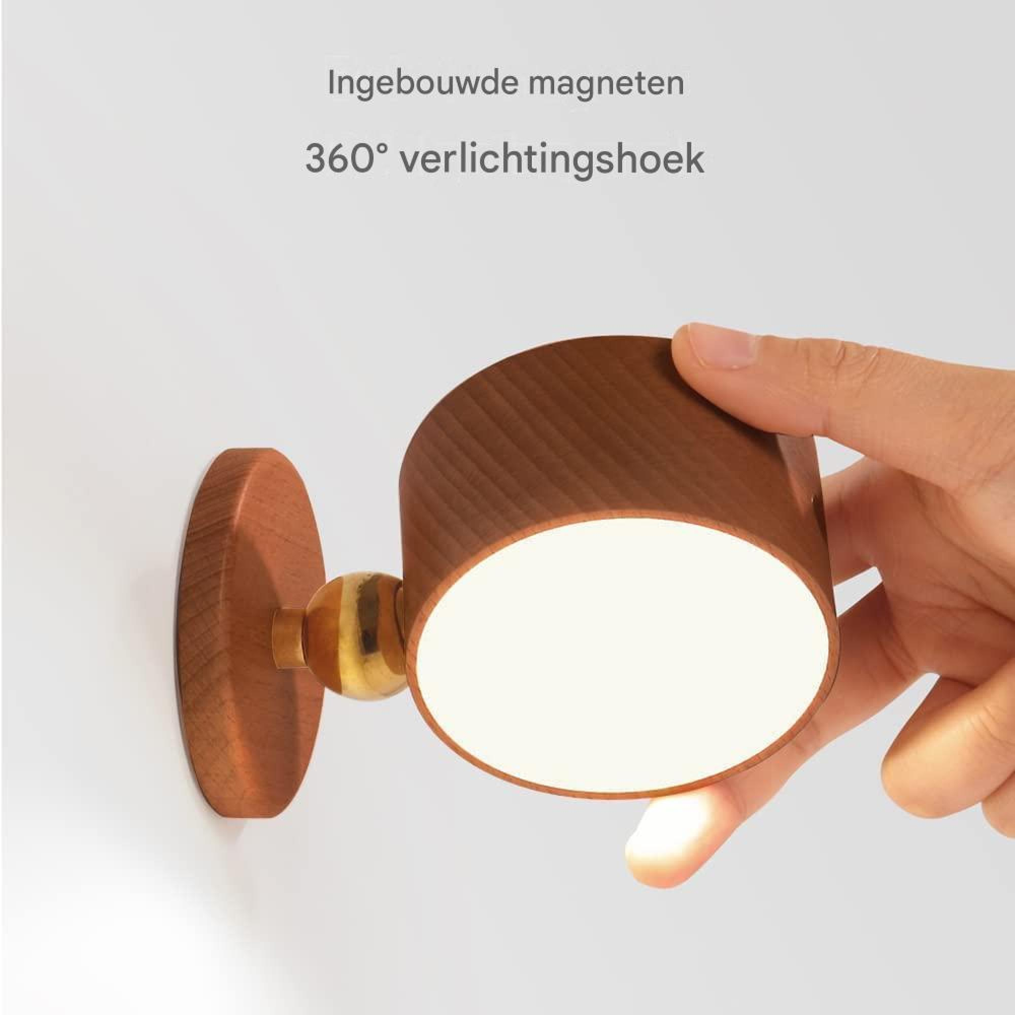 Ein hölzerner Wandspot mit Messinggelenk wird von einer Hand gehalten.