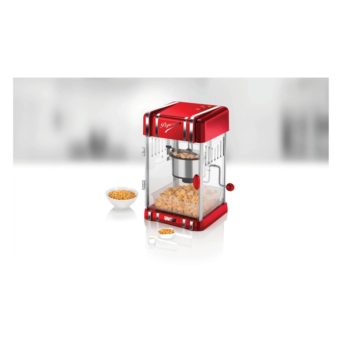 Máquina de palomitas roja retro con palomitas dentro y un cuenco de granos.