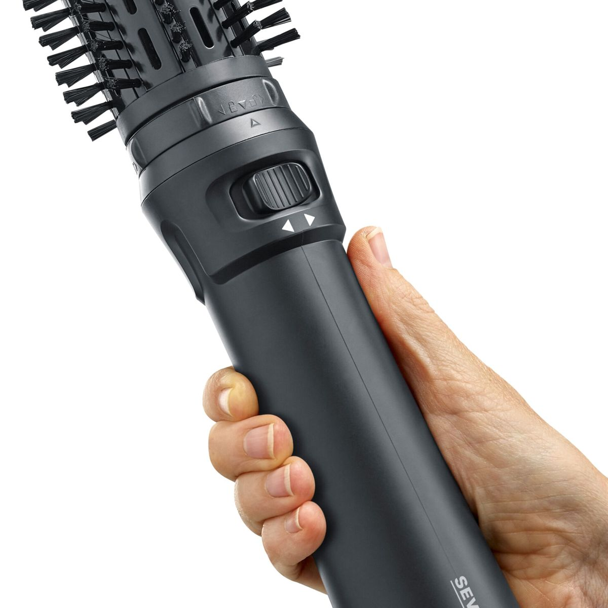 Una mano sostiene un cabezal de cepillo secador de pelo giratorio oscuro.