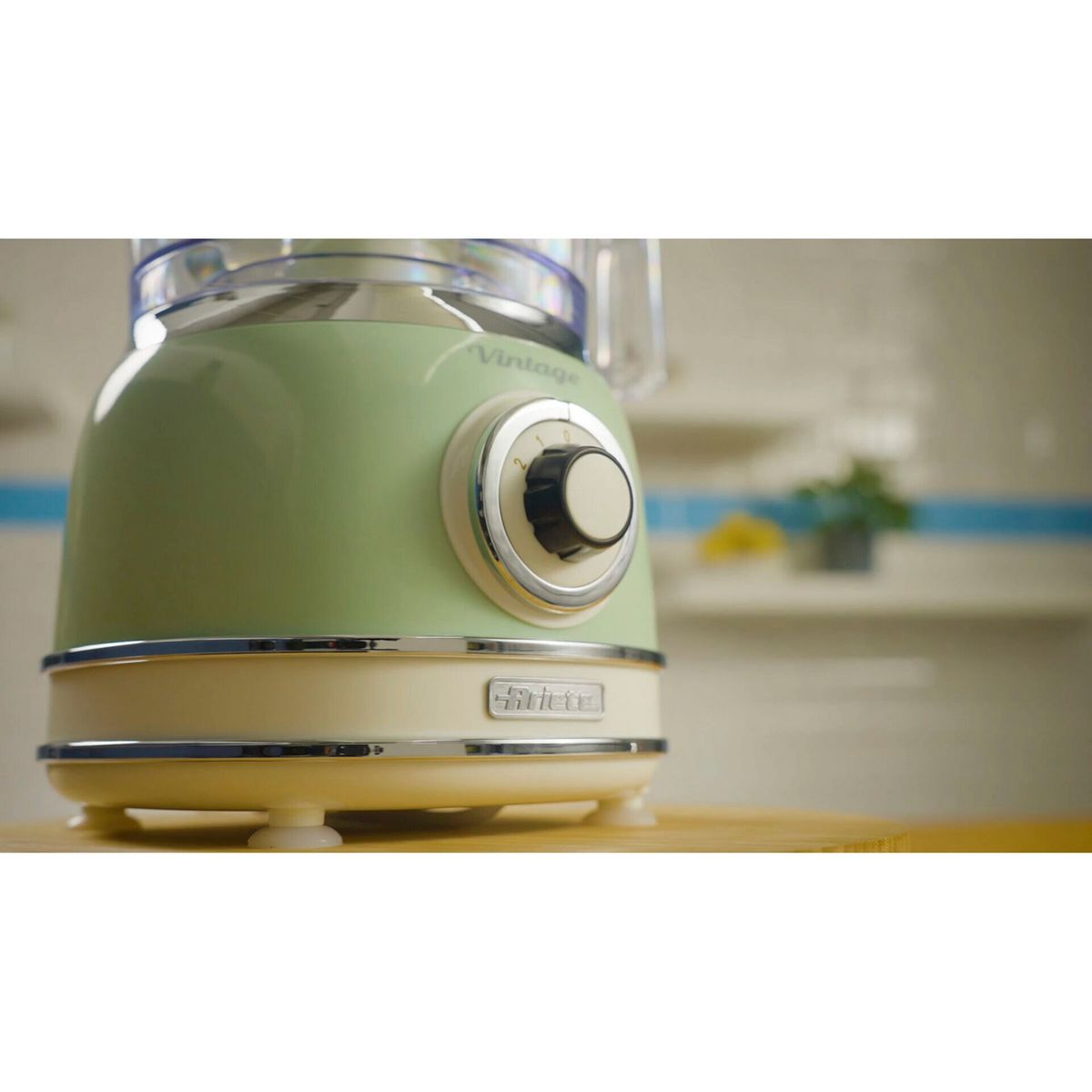 Robot da cucina vintage verde con base panna e accenti cromati.