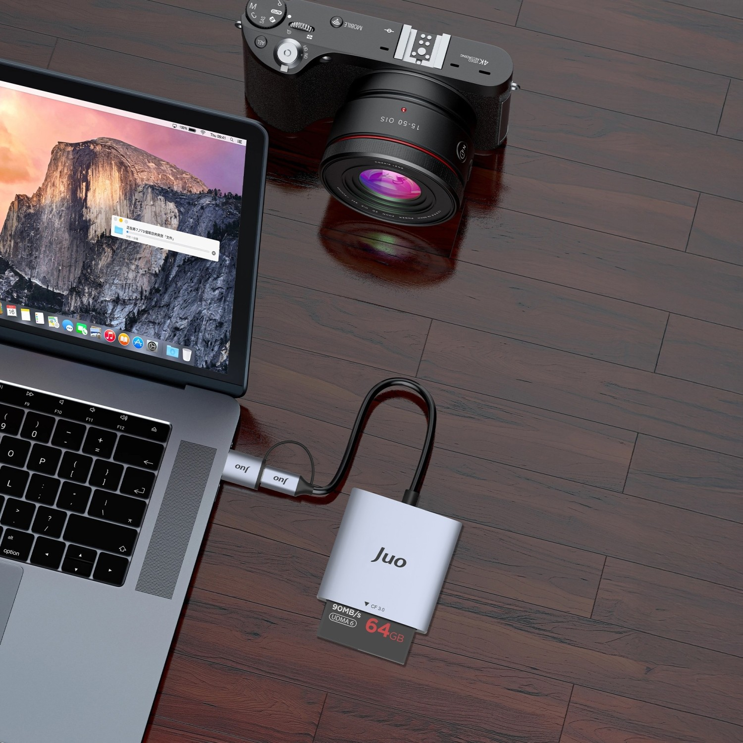 Ahşap bir masada kamera, kart okuyucu ve 64 GB hafıza kartı bulunan dizüstü bilgisayar.