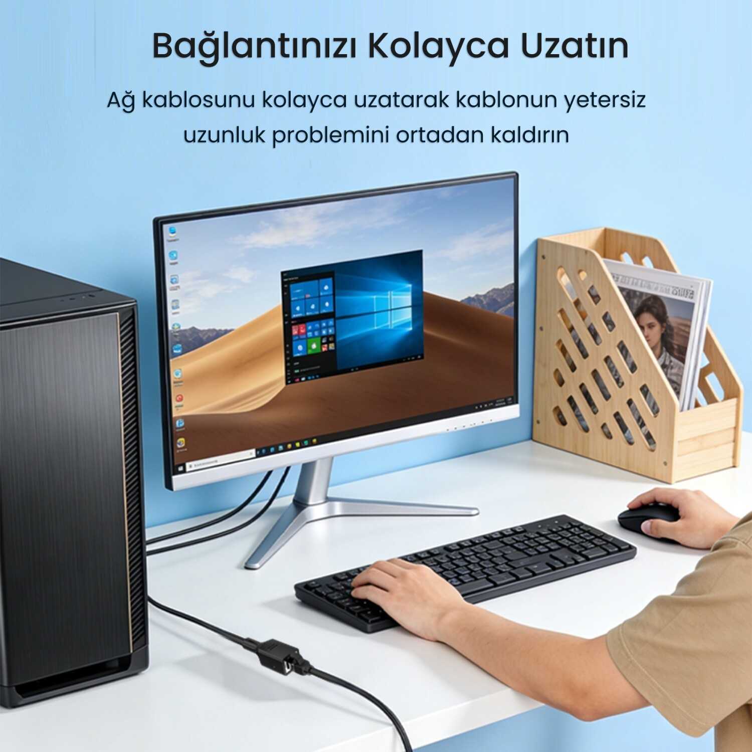 Bir masada bilgisayar, monitör, klavye, fare ve dergilik.