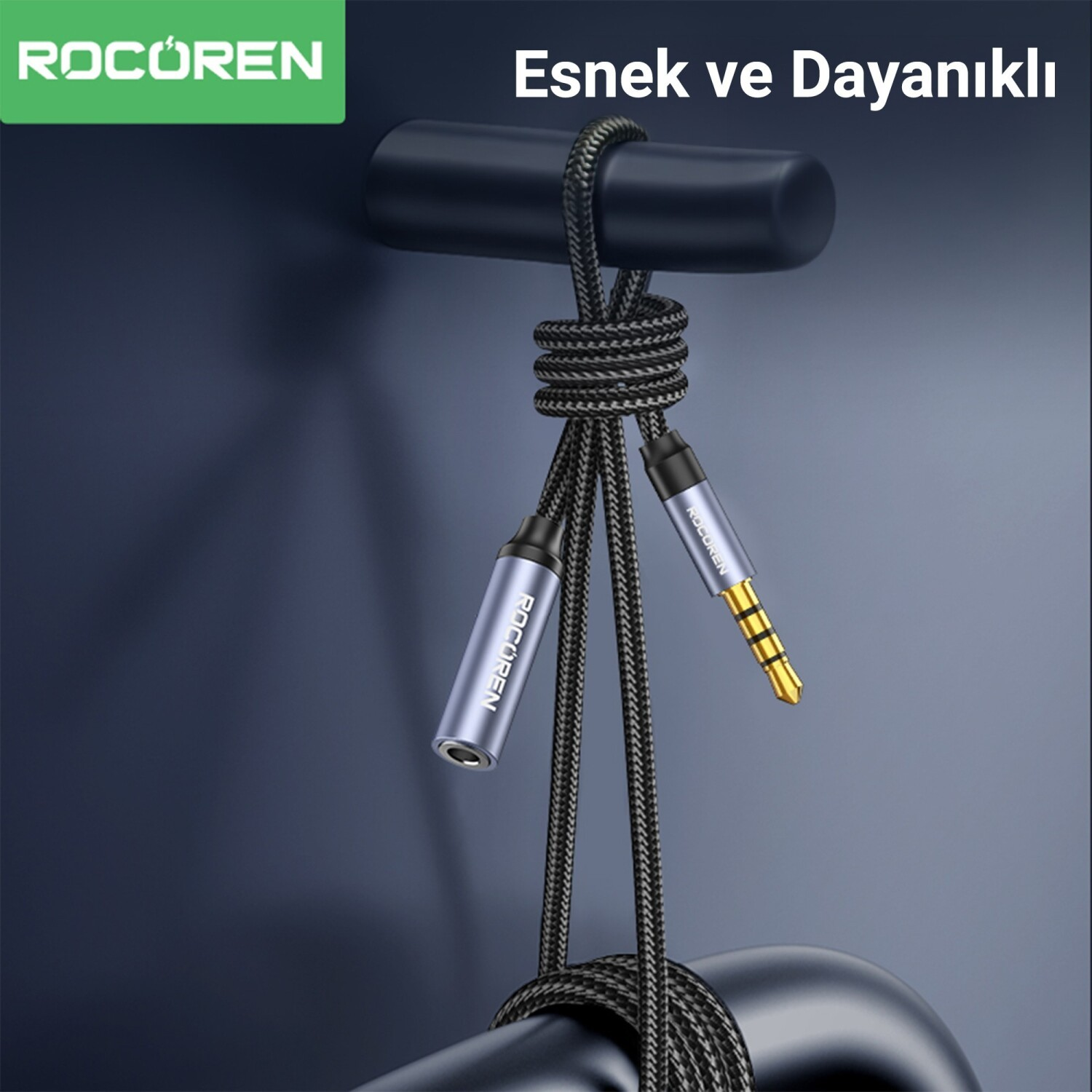 Koyu renkli bir kancadan sarkan, iki konektörlü siyah örgülü ses kablosu.