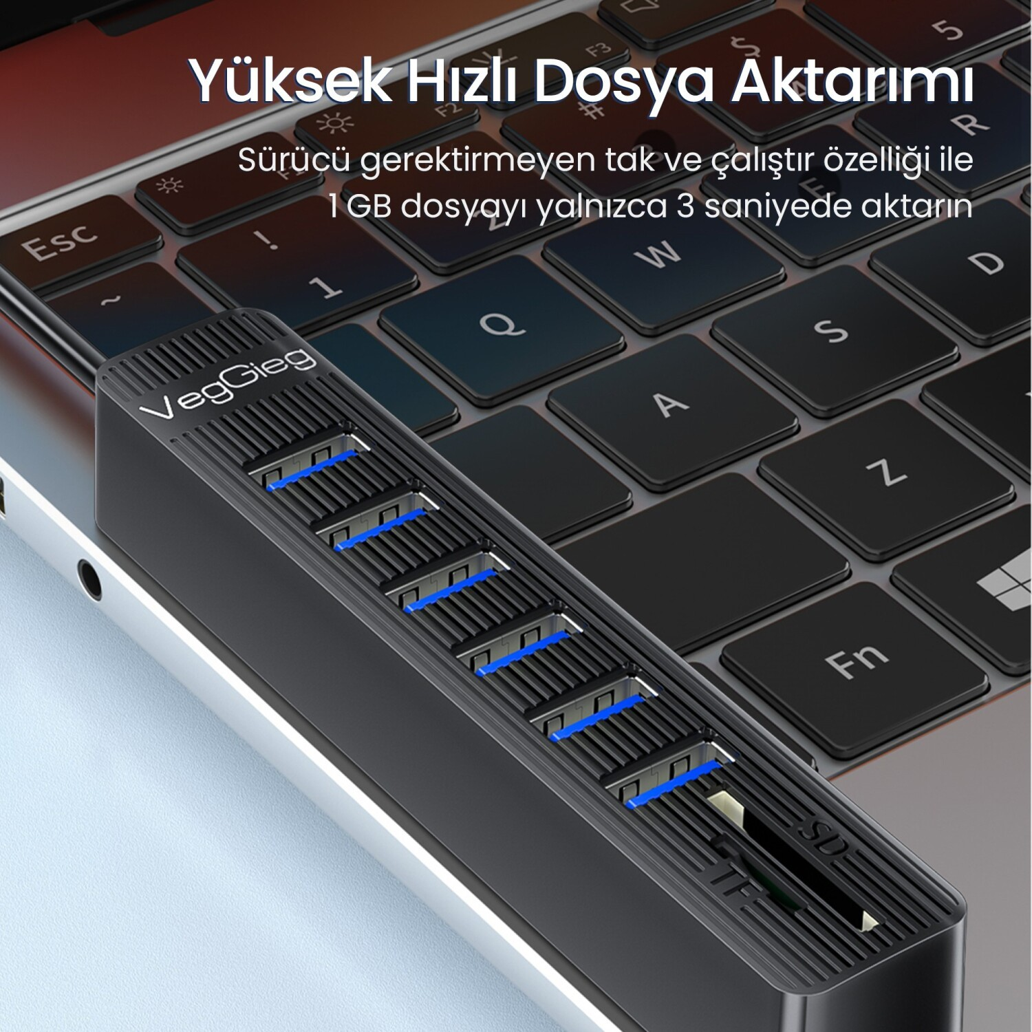 Siyah çok portlu USB hub, bir dizüstü bilgisayar klavyesinde.
