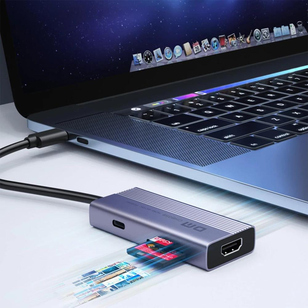 SD kartlı ve HDMI bağlantı noktalı gri USB-C hub bir dizüstü bilgisayara bağlıdır.