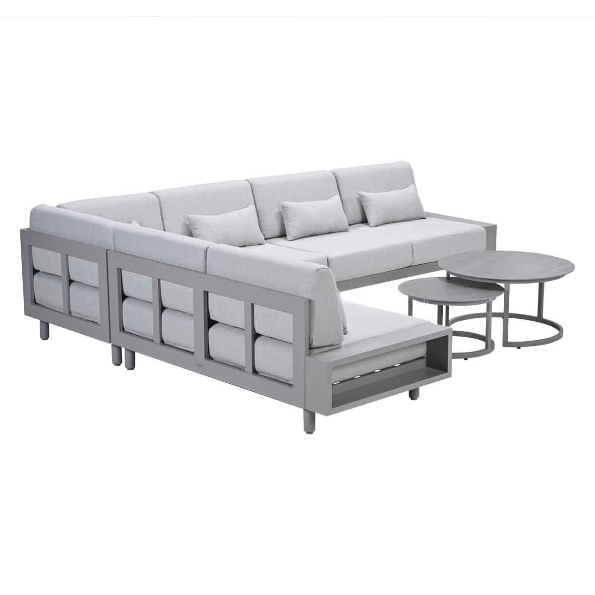 Grey sectional sofa with cushions and two round coffee tables.