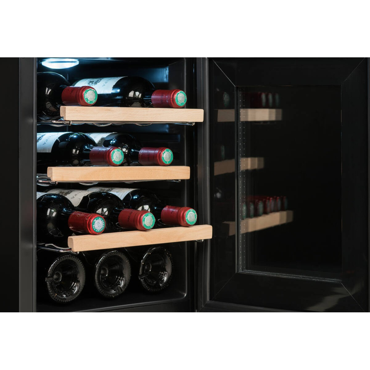 Una vinoteca con estantes de madera, llena de botellas oscuras y tapas rojas.