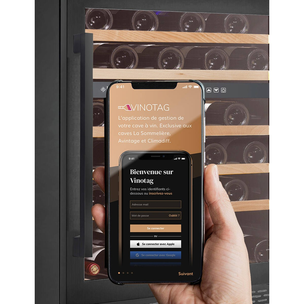 Una mano sostiene un smartphone que muestra la app Vinotag frente a una vinoteca.