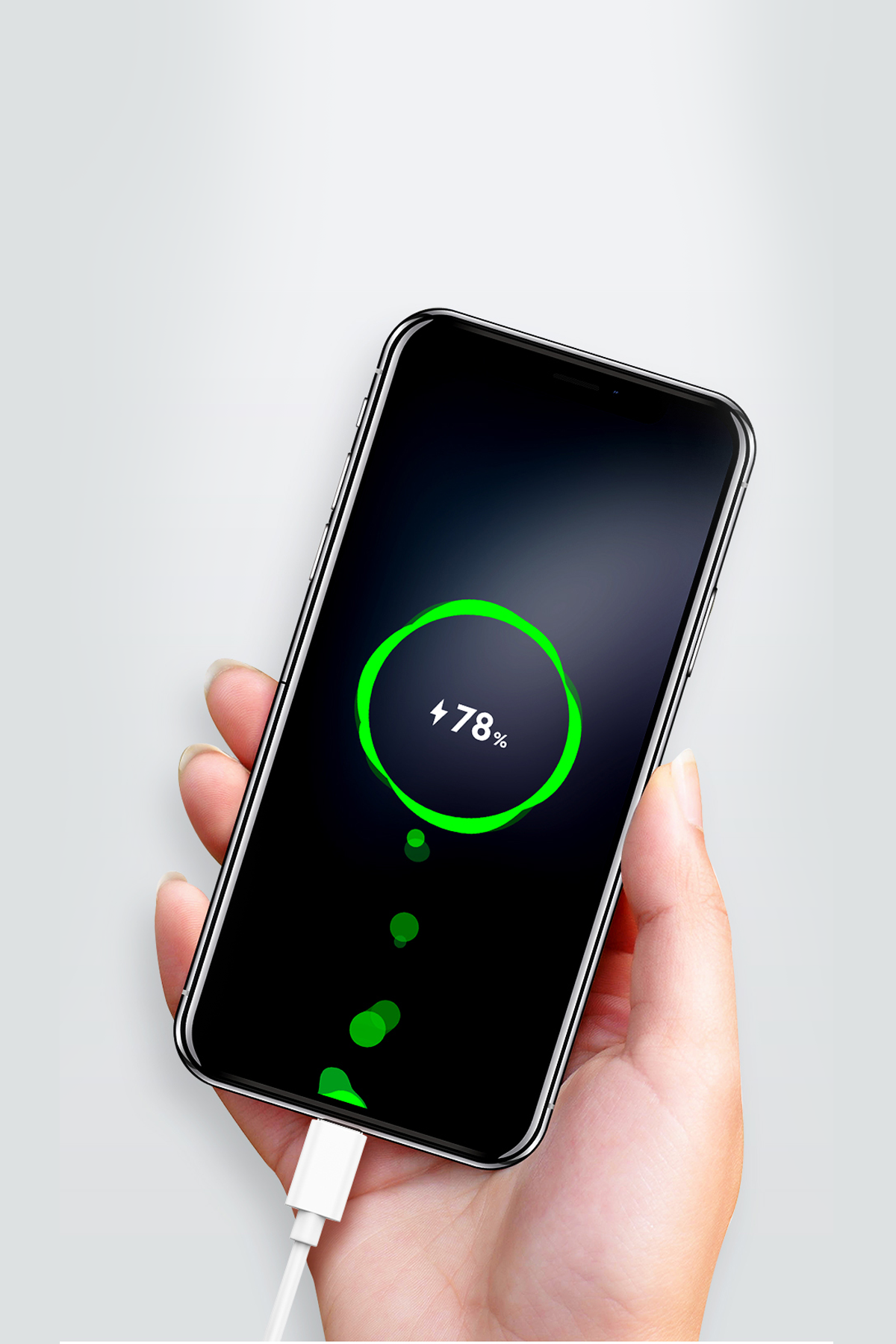 Bir el, beyaz şarj kablosuyla %78 şarj edilmiş bir akıllı telefonu tutuyor.