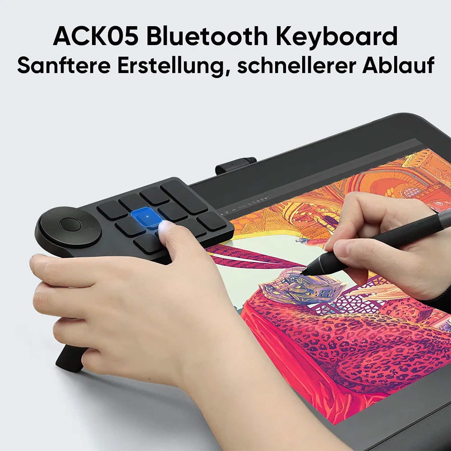 Person zeichnet auf einem Grafiktablett mit einer Hand und benutzt eine Tastatur mit der anderen.