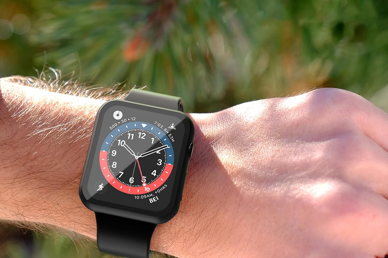 Un reloj inteligente con pantalla analógica en una muñeca, con fondo verde desenfocado.