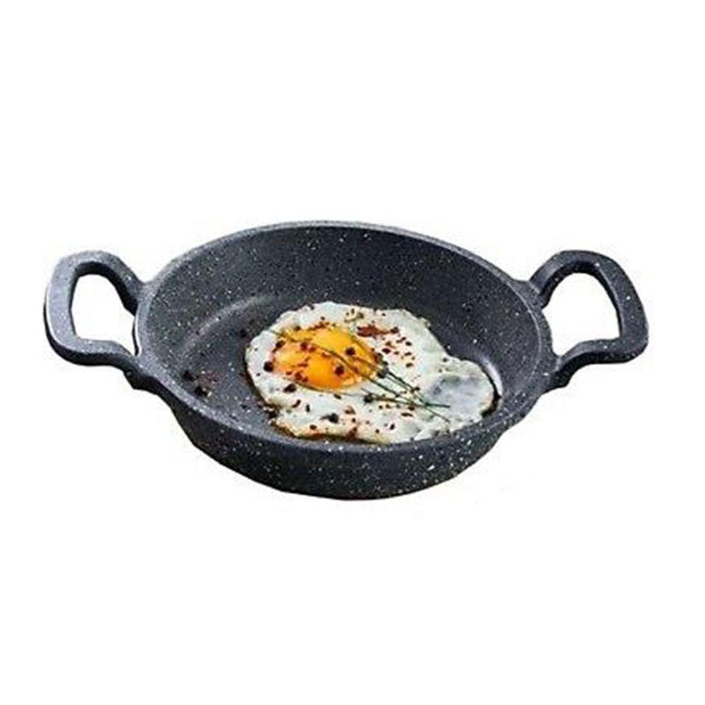 İki kulplu küçük bir tavada baharatlı sahanda yumurta.
