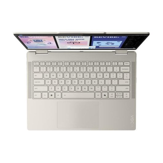 Un portátil abierto, color crema, mostrando teclado y tres pantallas.