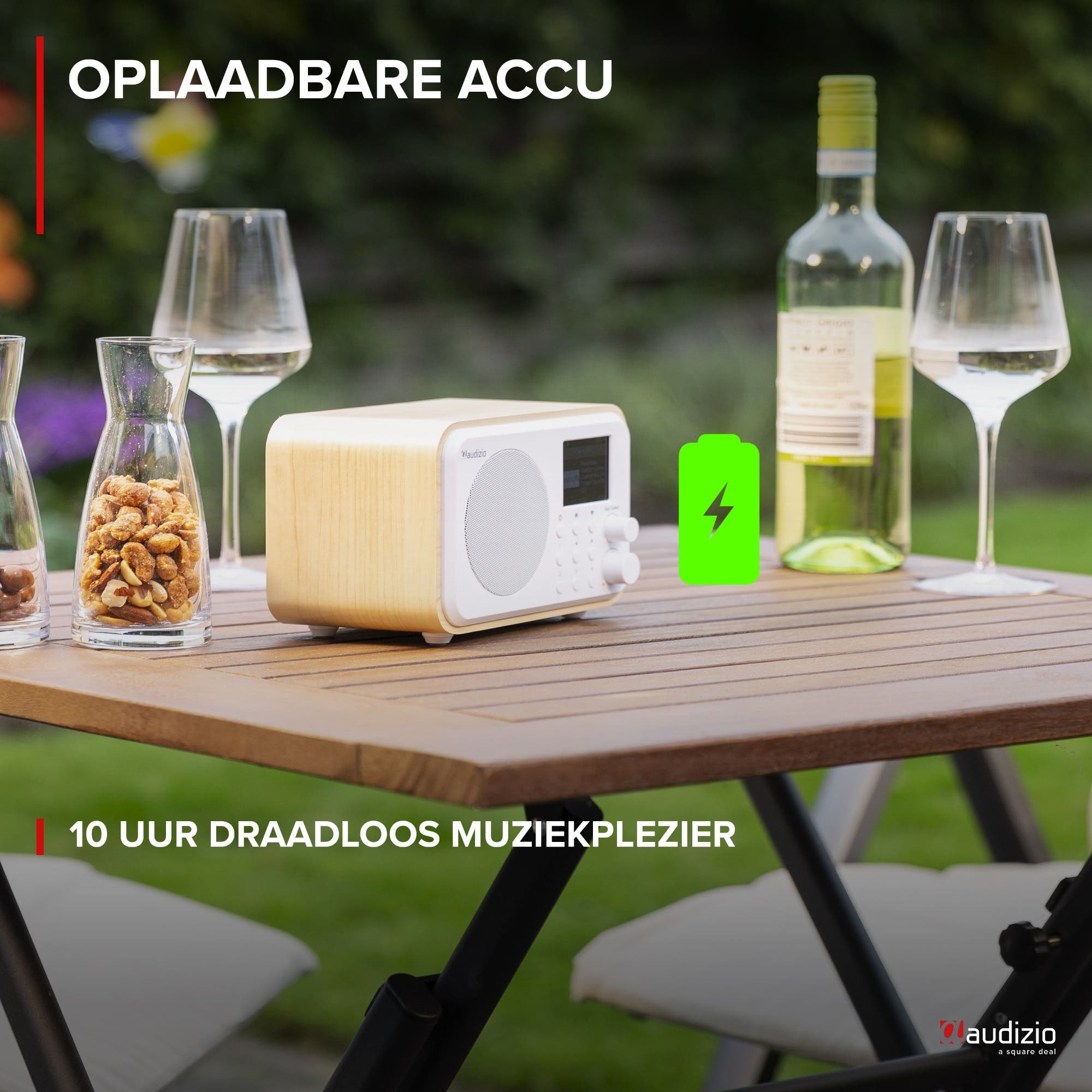 Radio de madera con bocadillos, vino y copas en mesa exterior.