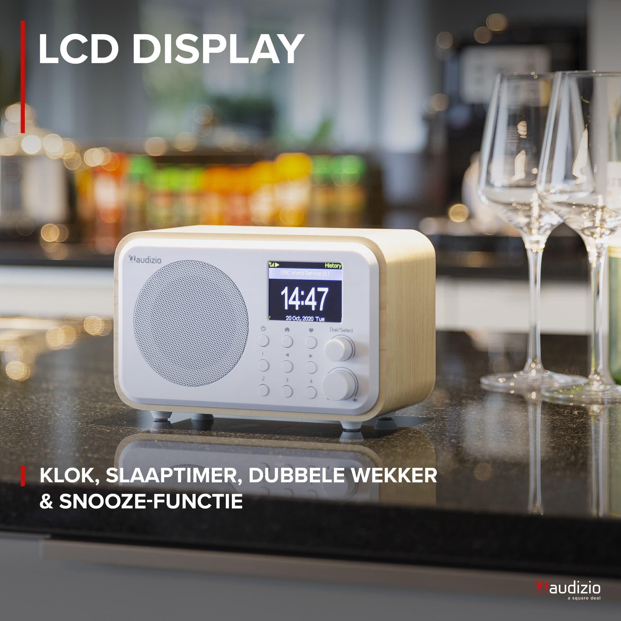Una radio Audizio blanca con detalles en madera muestra las 14:47 en pantalla LCD.