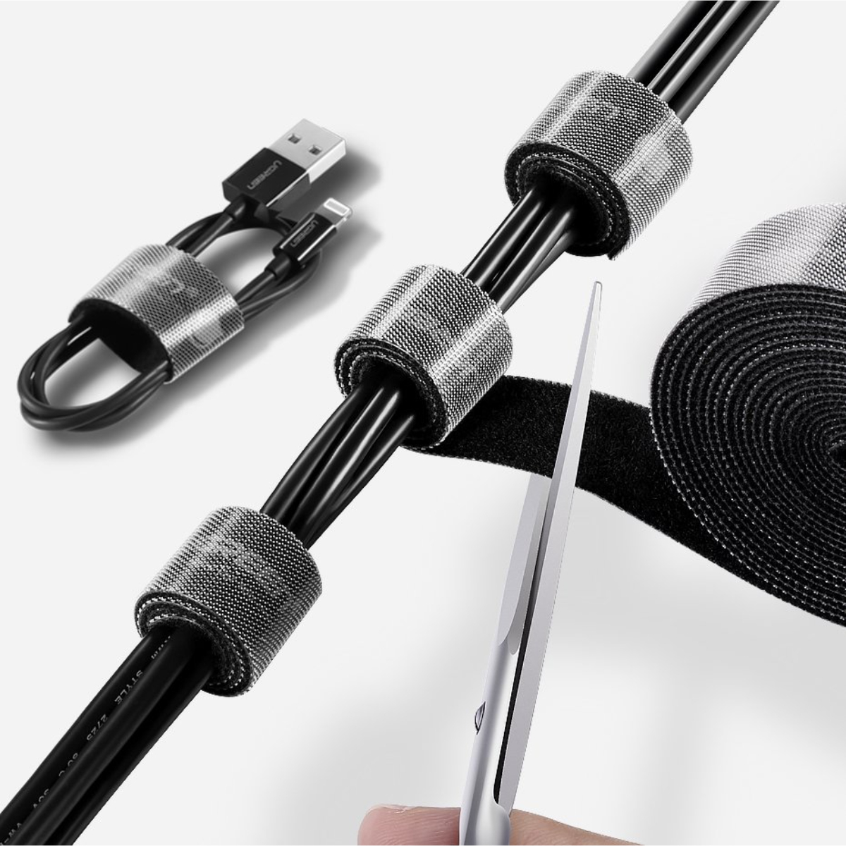 Kabelbinder um schwarze Kabel mit einer Schere, die sie zuschneidet.
