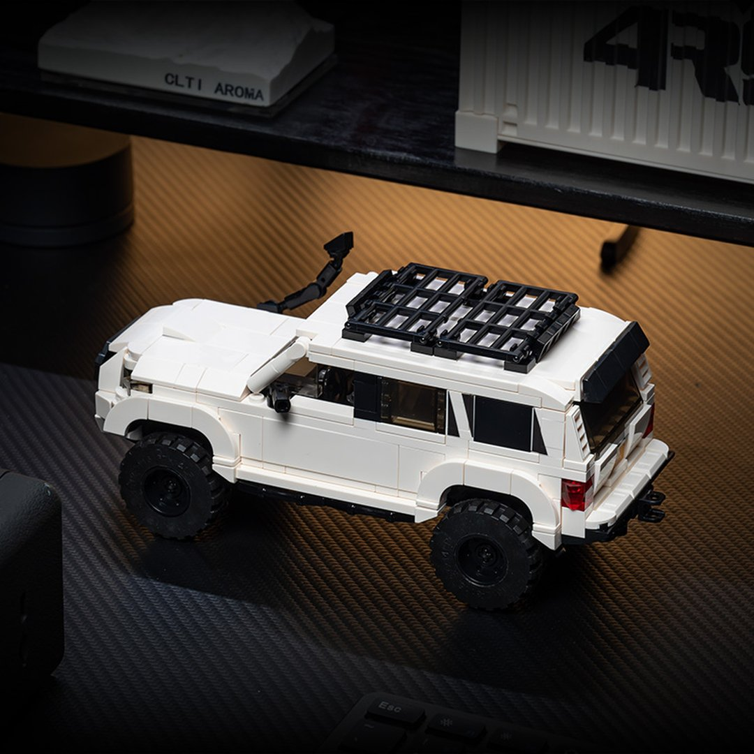 Biały SUV Lego z czarnym bagażnikiem dachowym i kołem zapasowym.