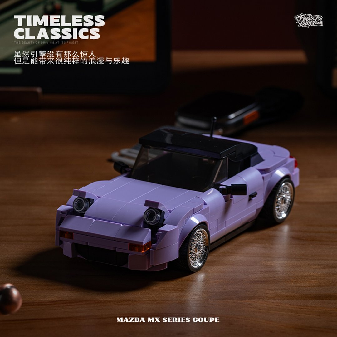 Fioletowy model Lego Mazda MX coupe stoi na drewnianym stole.