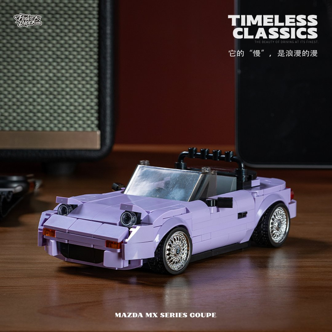 Lawendowy Lego Mazda MX Series Coupe stoi na drewnianym stole.