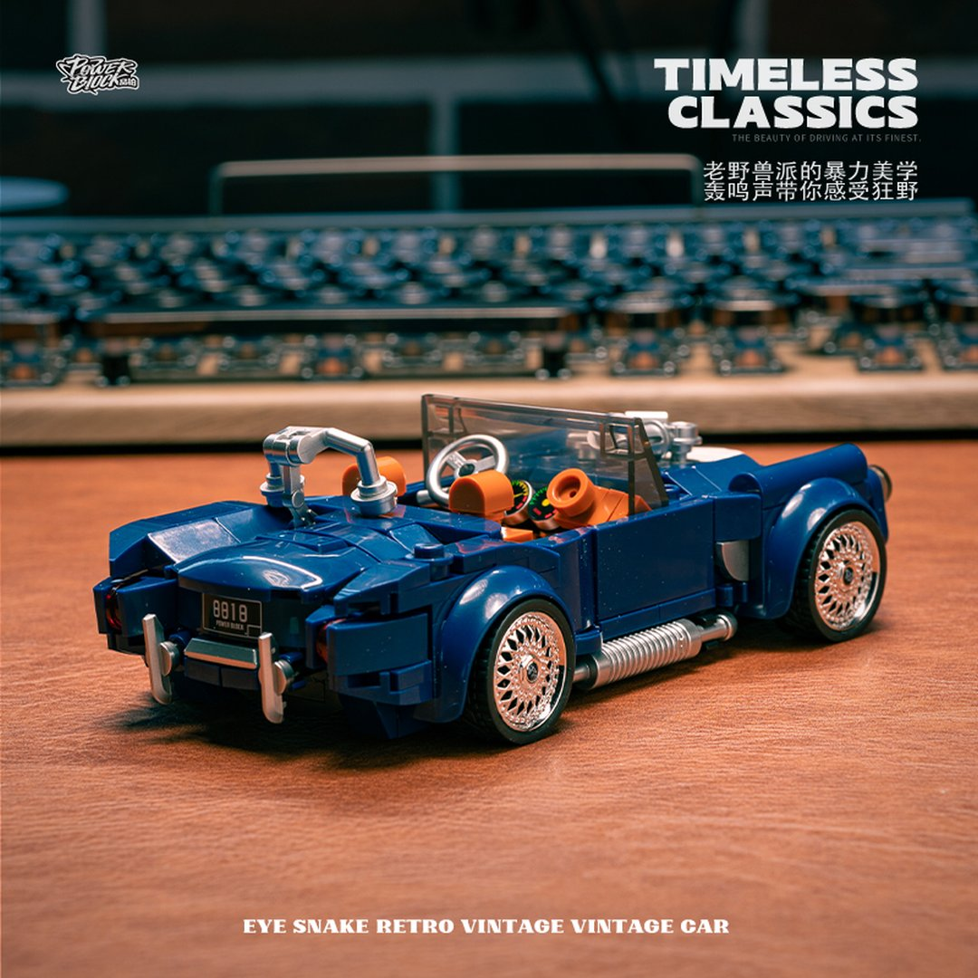 Niebieski kabriolet LEGO z chromowanymi kołami i pomarańczowymi siedzeniami na drewnie.