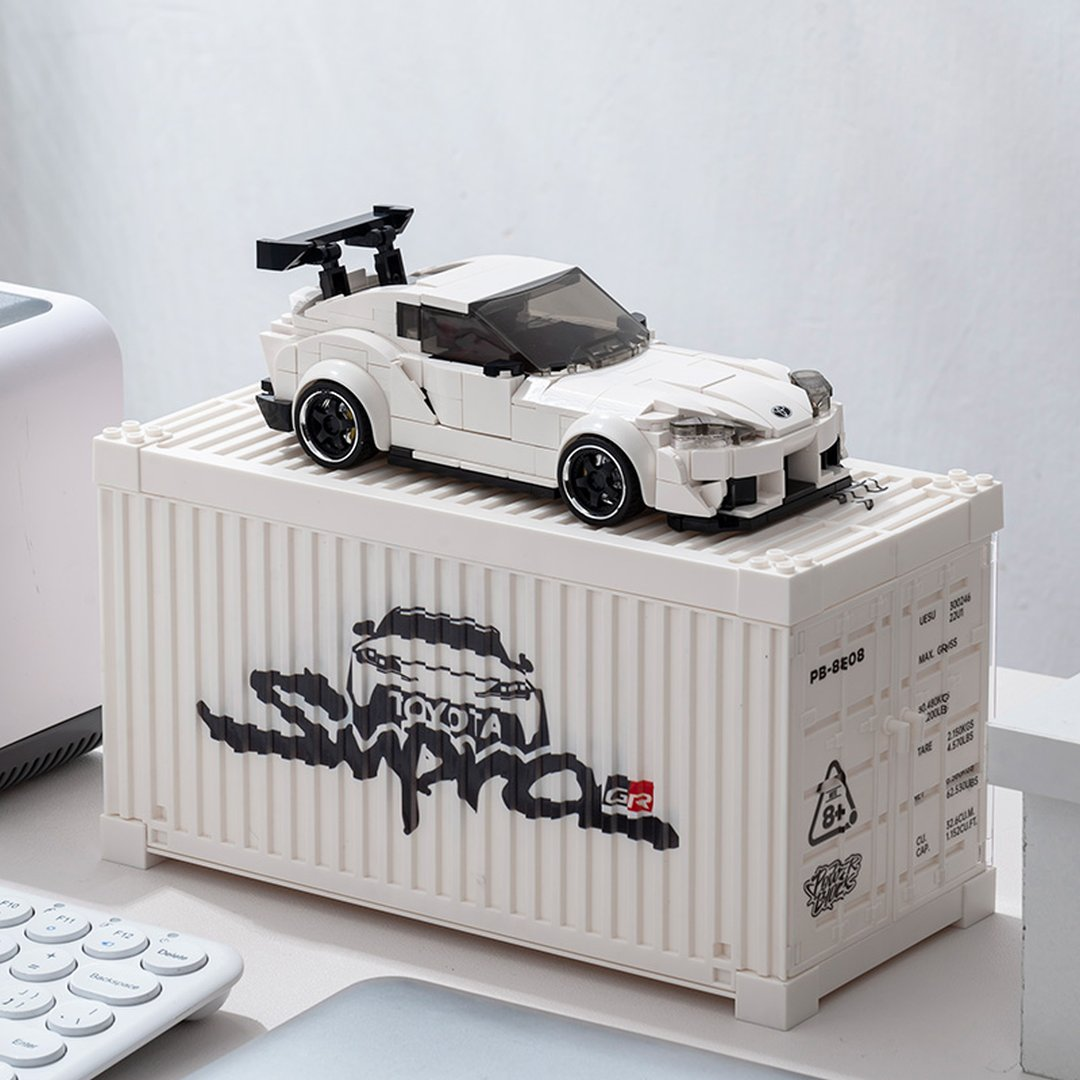 Biały samochód Lego ze spojlerem na białym kontenerze z grafiką Toyoty.