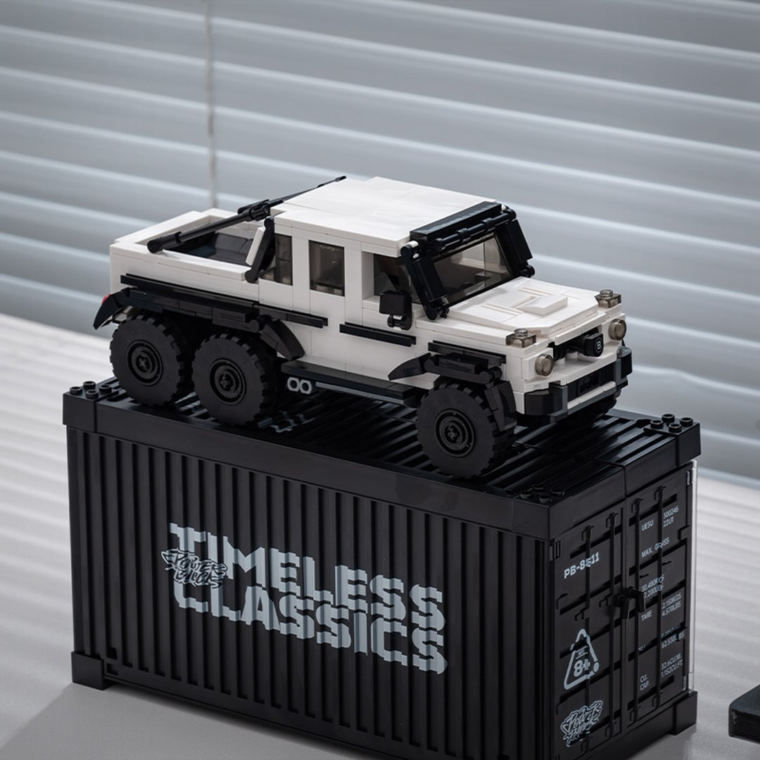 Biała ciężarówka Lego z 6 kołami na czarnym kontenerze morskim Lego z napisem "Timeless Classics".