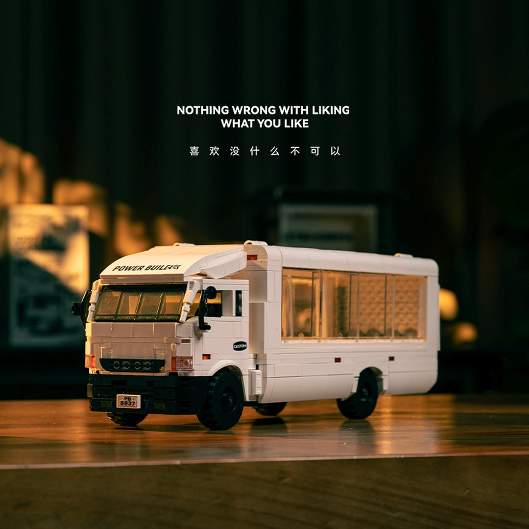 Biały autobus Lego na drewnianym stole. Tekst w tle.