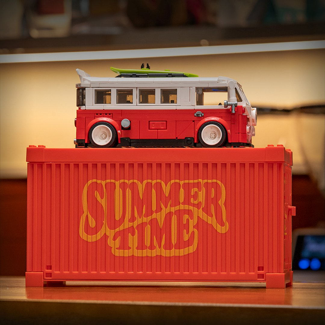 Czerwono-biały van Lego stoi na czerwonym kontenerze z napisem 'Summer Time'.